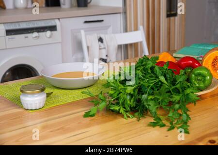 Hühnerbrühe mit Gemüsebouillon in einem Topf zubereiten. Schwarze Tafel als Hintergrund. Küche Arbeitsplatte Landschaft von oben. Stockfoto
