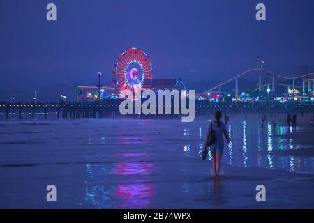 Frau, die am Santa Monica Beach, Santa Monica Pier, Kalifornien, USA spazieren geht Stockfoto