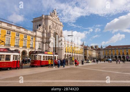 Lissabon, Portugal - 2. März 2020: Zwei rote Straßenbahnen 28 am Praca do Comercio vor Arco da Rua Augusta Stockfoto