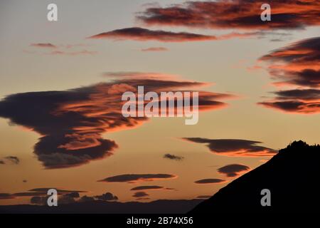 Schöne Lentikularwolken über Sierra Elvira in Granada bei Sonnenuntergang Stockfoto