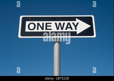 28.09.2019, Sydney, New South Wales, Australien - Einweg-Straßenschild mit Richtungspfeil vor blauem Himmel auf einem Parkdeck an einem Flughafen. [Automatisierte Übersetzung] Stockfoto