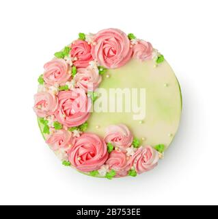 Draufsicht auf cremefarbenen Kuchen, der mit rosa Rosen verziert ist, die auf Weiß isoliert sind Stockfoto