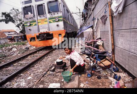 08.08.2009, Jakarta, Java, Indonesien, Asien - EINE Frau kocht Reis an ihrem Kochplatz neben den Schienen der Senner Eisenbahnlinie in einem Slumgebiet der indonesischen Hauptstadt. [Automatisierte Übersetzung] Stockfoto