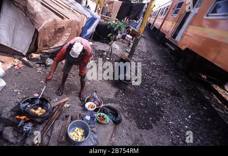 10.08.2009, Jakarta, Java, Indonesien, Asien - EIN Mann kocht Essen an einem Kochplatz neben den Bahngleisen in einem Slumgebiet der indonesischen Hauptstadt. [Automatisierte Übersetzung] Stockfoto