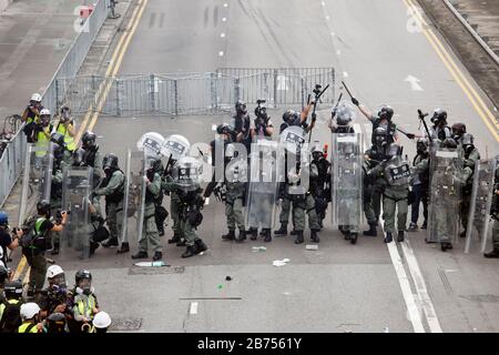 Demonstranten werfen Objekte zur Polizei im Yuen Long District in Hongkong. Der Polizei wurde vorgeworfen, die Bürger bewusst nicht vor dem Angriff auf unschuldige Zugpassagiere in Yuen Long am 21. Juli 2019 geschützt zu haben. Stockfoto