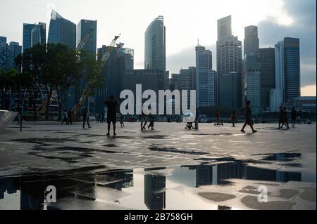 05.04.2019, Singapur, Republik Singapur, Asien - Menschen an der Promenade in der Marina Bay mit der Skyline des Geschäftsviertels im Hintergrund. [Automatisierte Übersetzung] Stockfoto