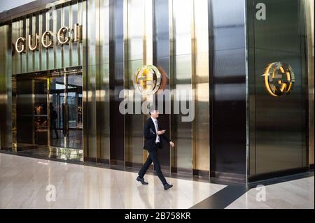 04.04.2018, Singapur, Republik Singapur, Asien - EIN Mann spaziert an einem Gucci-Laden in den Shoppes in Marina Bay Sands vorbei. Neben Luxusgeschäften befinden sich im gesamten Komplex das Marina Bay Sands Hotel und ein Casino. [Automatisierte Übersetzung] Stockfoto