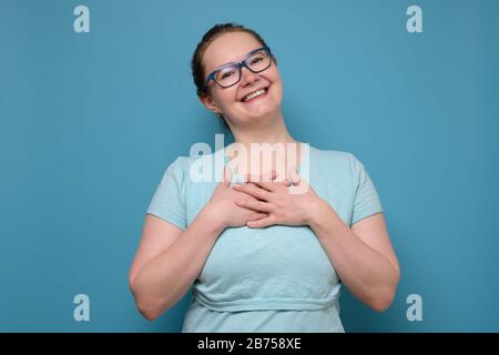 Schöne attraktive lächelnde Frau, die positive Emotionen und Gefühle zum Ausdruck bringt, die mit Kompliment zufrieden sind. Schönheits- und Jugendkonzept Stockfoto