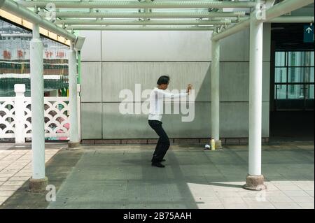 18.04.2018, Singapur, Republik Singapur, Asien - EIN Mann übt Tai Chi in einem kleinen Park außerhalb des People's Park Complex im Chinatown-Viertel in Singapur aus. [Automatisierte Übersetzung] Stockfoto