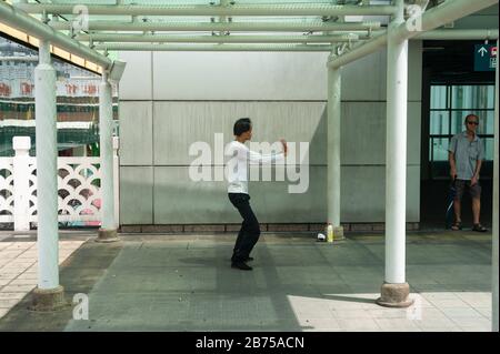 18.04.2018, Singapur, Republik Singapur, Asien - EIN Mann übt Tai Chi in einem kleinen Park außerhalb des People's Park Complex im Chinatown-Viertel in Singapur aus. [Automatisierte Übersetzung] Stockfoto