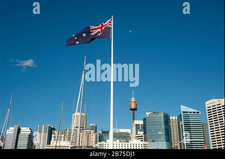 20.09.2018, Sydney, New South Wales, Australien - EINE riesige australische Flagge überfliegt Darling Harbour mit der Skyline des Geschäftsviertels von Sydney und dem Sydney Tower im Hintergrund. [Automatisierte Übersetzung] Stockfoto