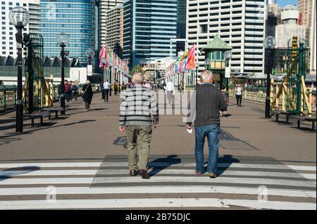 18.09.2018, Sydney, New South Wales, Australien - Fußgänger, die Cockle Bay auf der Pyrmont Bridge am Darling Harbour mit Gebäuden des Geschäftsviertels Sydney im Hintergrund überqueren. [Automatisierte Übersetzung] Stockfoto