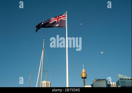 20.09.2018, Sydney, New South Wales, Australien - EINE riesige australische Flagge überfliegt Darling Harbour mit der Skyline des Geschäftsviertels von Sydney und dem Sydney Tower im Hintergrund. [Automatisierte Übersetzung] Stockfoto