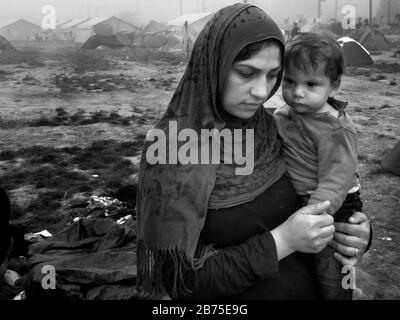 Flüchtlingslager in Idomeni an der Grenze zu Mazedonien. Eine Mutter mit ihrem Kind. [Automatisierte Übersetzung] Stockfoto