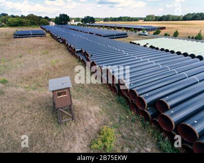 Blick auf die in der Nähe der Stadt Bindow in Brandenburg in einem offenen Lagerbereich gelegenen Pipelines und den Bau der European Gas Link, EUGAL, steht bevor. Die Pipeline soll etwa 480 Kilometer von der Ostsee durch Mecklenburg-Vorpommern und Brandenburg bis in den Süden Sachsens und von dort über die Grenze nach Tschechien führen. Die erste Linie der EUGAL soll bis Ende 2019 fertiggestellt werden. Das Erdgas für EUGAL wird über die Nord Stream 2-Pipeline durch die Ostsee geliefert. [Automatisierte Übersetzung] Stockfoto