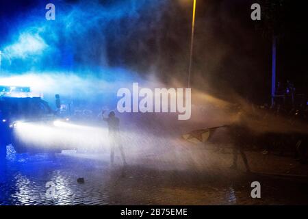 Ein Demonstrant konfrontiert einen gepanzerten Wagen der Polizei. [Automatisierte Übersetzung] Stockfoto