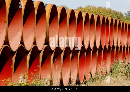 Blick auf die in der Nähe der Stadt Bindow in Brandenburg in einem offenen Lagerbereich gelegenen Pipelines und den Bau der European Gas Link, EUGAL, steht bevor. Die Pipeline soll etwa 480 Kilometer von der Ostsee durch Mecklenburg-Vorpommern und Brandenburg bis in den Süden Sachsens und von dort über die Grenze nach Tschechien führen. Die erste Linie der EUGAL soll bis Ende 2019 fertiggestellt werden. Das Erdgas für EUGAL wird über die Nord Stream 2-Pipeline durch die Ostsee geliefert. [Automatisierte Übersetzung] Stockfoto