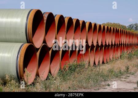 Blick auf die in der Nähe der Stadt Bindow in Brandenburg in einem offenen Lagerbereich gelegenen Pipelines und den Bau der European Gas Link, EUGAL, steht bevor. Die Pipeline soll etwa 480 Kilometer von der Ostsee durch Mecklenburg-Vorpommern und Brandenburg bis in den Süden Sachsens und von dort über die Grenze nach Tschechien führen. Die erste Linie der EUGAL soll bis Ende 2019 fertiggestellt werden. Das Erdgas für EUGAL wird über die Nord Stream 2-Pipeline durch die Ostsee geliefert. [Automatisierte Übersetzung] Stockfoto