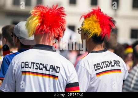 Deutsche Fußballfans werden am 17. Juni 2018 auf der Brandenburger Pforte in der Berliner Fanmeile schwarze und rote und goldene peruanische Trikots und Deutschland Trikots für das Eröffnungsspiel zwischen Deutschland und Mexiko tragen. [Automatisierte Übersetzung] Stockfoto