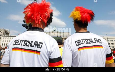 Deutsche Fußballfans werden am 17. Juni 2018 auf der Brandenburger Pforte in der Berliner Fanmeile schwarze und rote und goldene peruanische Trikots und Deutschland Trikots für das Eröffnungsspiel zwischen Deutschland und Mexiko tragen. [Automatisierte Übersetzung] Stockfoto