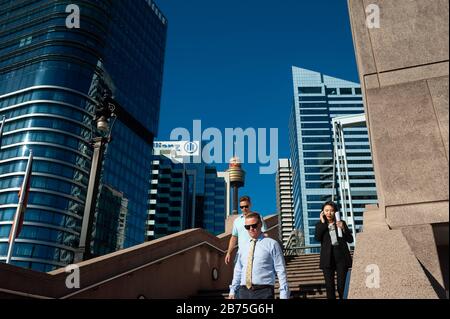 07.05.2018, Sydney, New South Wales, Australien - Büroangestellte sind auf dem Weg zum Darling Harbour mit der Skyline von Sydneys Geschäftsviertel und dem Sydney Tower im Hintergrund. [Automatisierte Übersetzung] Stockfoto