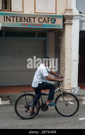 31.01.2018, Singapur, Republik Singapur, Asien - EIN Radfahrer steht vor einem geschlossenen Internetcafé im Singapur-Distrikt Little India. [Automatisierte Übersetzung] Stockfoto