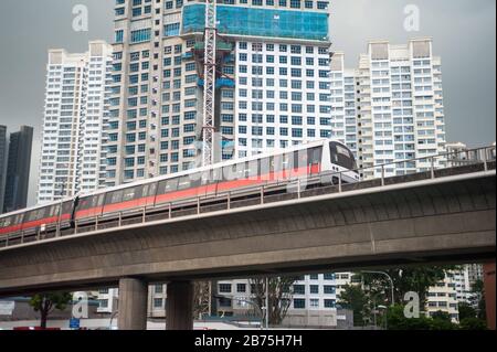 14.12.2017, Singapur, Republik Singapur, Asien - ein MRT-Stadtbahnsystem führt auf erhöhter Strecke durch ein Wohngebiet in Singapur. Im Hintergrund werden neue Mietshäuser gebaut. [Automatisierte Übersetzung] Stockfoto