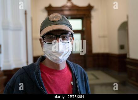 Texas, USA. März 2020. Ein Tourist im Texas Capitol in Austin trägt eine Maske als reg. Greg Abbott hält in seinem Kapitolbüro eine Pressekonferenz ab, in der er eine "Katastrophe" als texanische Klammern für einen Ansturm von Coronavirus-Fällen erklärt. ING-Einrichtung in San Antonio. Credit: Bob Daemmrich/Alamy Live News Stockfoto