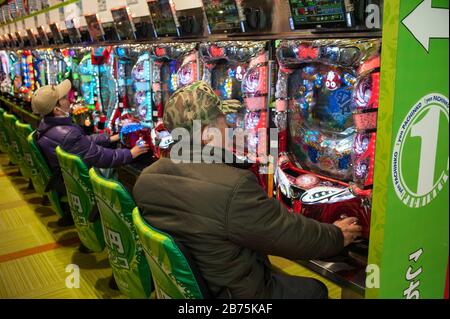 24.12.2017, Kyoto, Japan, Asien - japanische Leute sitzen vor Spielautomaten in einer Spielhalle in Kyoto und verstreichen die Zeit mit Pachinko. Japan erwirtschaftet mehr als 4 % seines jährlichen Bruttoinlandsprodukts, 25 Billionen ¥(185 Milliarden Euro), aus dem Verkauf von Spielsucht. [Automatisierte Übersetzung] Stockfoto