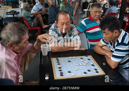 29.09.2017, Singapur, Republik Singapur, Asien - ältere Männer spielen chinesisches Schach, auch Xiangqi genannt, auf einem öffentlichen Platz neben dem Buddha-Zahnrelikempel im singapurischen Distrikt Chinatown. Oft sind kleinere Geldbeträge beteiligt. [Automatisierte Übersetzung] Stockfoto