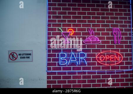 23.07.2017, Singapur, Republik Singapur, Asien - beleuchtete Plakate für eine Bar finden Sie im Chinatown-Viertel von Singapur direkt neben einem Verbotsschild. Aus diesem Grund wird Singapur oft als Stadt der Geldstrafen bezeichnet. [Automatisierte Übersetzung] Stockfoto