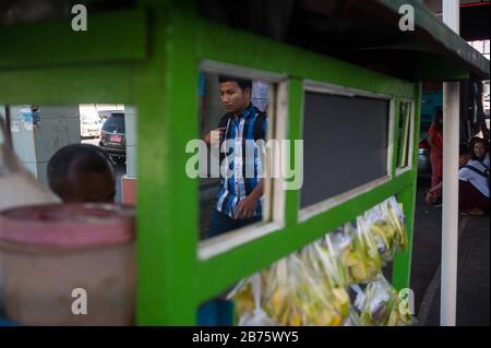 27.01.2017, Yangon, Yangon Region, Republik der Union von Myanmar, Asien - EIN Mann, der zu Fuß unterwegs ist, spiegelt sich in einem Mango-Stand wider. [Automatisierte Übersetzung] Stockfoto