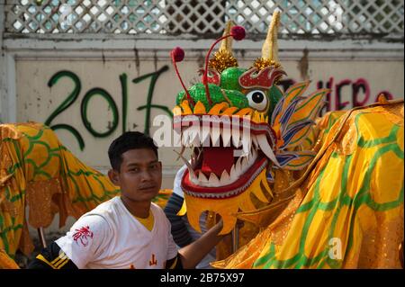 31.01.2017, Mawlamyine, Republik der Union von Myanmar, Asien - EINE Tänzerin steht neben einem Drachenkostüm während der chinesischen Neujahrsfeier in Mawlamyine. [Automatisierte Übersetzung] Stockfoto