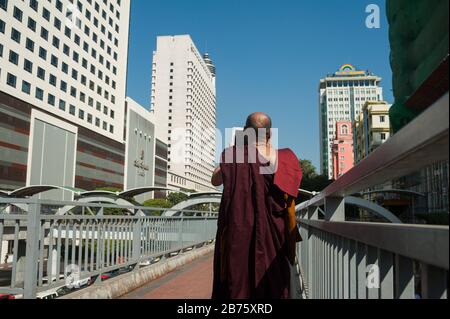 27.01.2017, Yangon, Yangon Region, Republik der Union von Myanmar, Asien - EIN buddhistischer Mönch steht auf einer Fußgängerbrücke und fotografiert das neue Gebäude am Sule Square im Zentrum von Yangon. [Automatisierte Übersetzung] Stockfoto