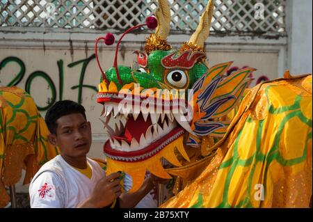 31.01.2017, Mawlamyine, Republik der Union von Myanmar, Asien - EINE Tänzerin steht neben einem Drachenkostüm während der chinesischen Neujahrsfeier in Mawlamyine. [Automatisierte Übersetzung] Stockfoto