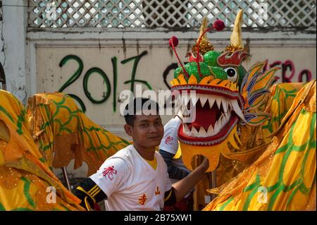 31.01.2017, Mawlamyine, Republik der Union von Myanmar, Asien - EINE Tänzerin steht neben einem Drachenkostüm während der chinesischen Neujahrsfeier in Mawlamyine. [Automatisierte Übersetzung] Stockfoto