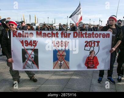 Teilnehmer der Demo "erkel muss gehen" halten ein Plakat mit der Aufschrift "keine Macht für Diktatoren" mit Bildern von Hitler, Honecker und Kanzlerin Angela Merkel. Demonstration von rechtspopulistischen und rechtsextremistischen Teilnehmern, darunter Anhänger von NPD, Pegida, von Bürgern des Reiches, von Rowdys, Landsleuten und Identitäten. [Automatisierte Übersetzung] Stockfoto