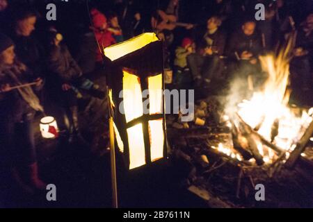 Rund um ein Lagerfeuer sitzen Kinder mit ihren Laternen zum St. Martinsfest am 17.11.2016. Jedes Jahr um den 11. November ziehen Kinderschwärme mit bunten Laternen durch die dunklen Straßen, die Martin- und Laternenlieder singen. [Automatisierte Übersetzung] Stockfoto