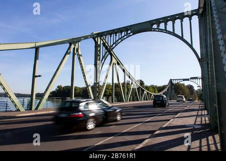 Autos fahren über die Glienicker Brücke . Die Glienicker Brücke bildet heute die Stadtgrenze zwischen Berlin und Potsdam und war zur Zeit der deutschen Teilung Grenzort und Umsteigepunkt für Spione aus Ost und West. [Automatisierte Übersetzung] Stockfoto