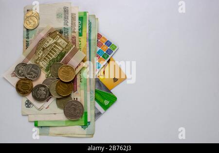 Russische Banknoten, Münzen und Bankkarten befinden sich auf einem weißen Hintergrund. Nahaufnahme. Stockfoto