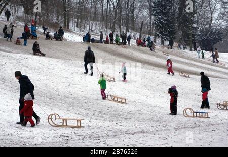 Im verschneiten Volkspark Friedrichshain schlittern am 07.01.16 Erwachsene und Kinder mit ihren Schlitten den Berg hinunter und klettern wieder hoch. [Automatisierte Übersetzung] Stockfoto