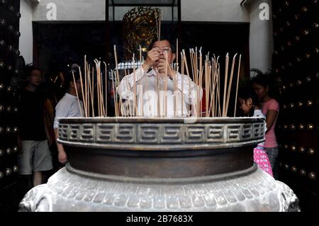 SINGAPUR, 19. Februar 2015 - EIN Mann betet am ersten Tag der mehrtägigen chinesischen Neujahrsfeierlichkeiten im Tempel der Buddha-Zahnrelika in Singapurs Chinatown. Das neue Jahr basiert auf dem chinesischen Mondkalender und steht unter dem Zeichen der Schafe oder der Ziege. Der Tempel ist eine der vielen Sehenswürdigkeiten des Stadtstaats, von denen drei Viertel aus Menschen chinesischer Abstammung bestehen. [Automatisierte Übersetzung] Stockfoto