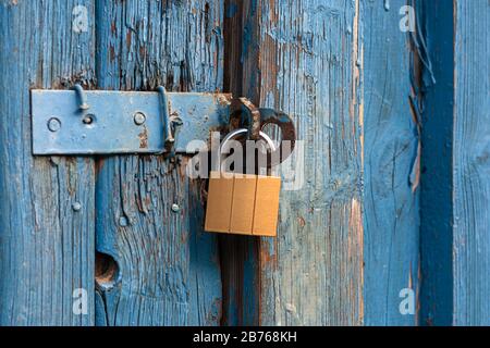 Alte Tür mit neuem Vorhängeschloss verschlossen Stockfoto