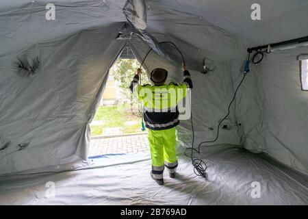 Ferrara, 13. März 2020. Freiwillige des italienischen Zivilschutzes "Protezione Civile" montieren ein Sanitätszelt aufgrund eines Coronavirus-Notfalls in Ferrara, Italien. Kredit: Filippo Rubin / Alamy Live News Stockfoto