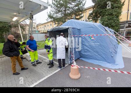 Ferrara, 13. März 2020. Freiwillige des italienischen Zivilschutzes "Protezione Civile" montieren ein Sanitätszelt aufgrund eines Coronavirus-Notfalls in Ferrara, Italien. Kredit: Filippo Rubin / Alamy Live News Stockfoto