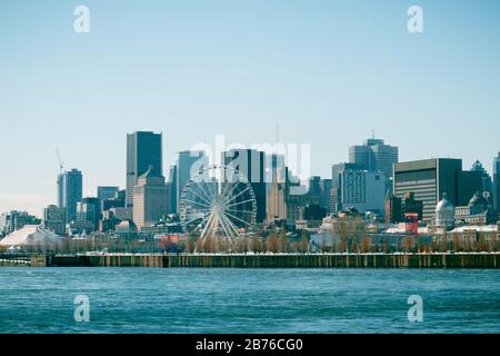 Montreal, Quebec, Kanada - März 2020 - Blick auf den Bezirk Vieux Montreal und das große Rad vom Fluss Saint Laurent im Winter Stockfoto