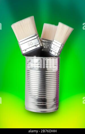 Zinn Paint CAN mit neuen Pinsel auf grünem abstraktem Hintergrund Stockfoto