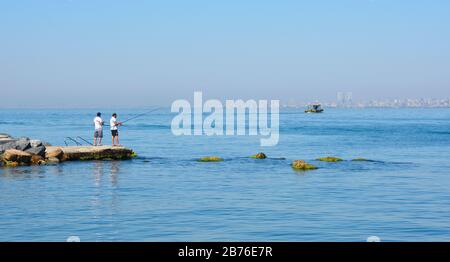 Buyukada, Türkei - 18. September 2020. Am Ufer der Insel Buyukada, einer der Prinzeninseln, die auch als "Adelar" bezeichnet wird, fangen zwei Einheimische Fisch Stockfoto