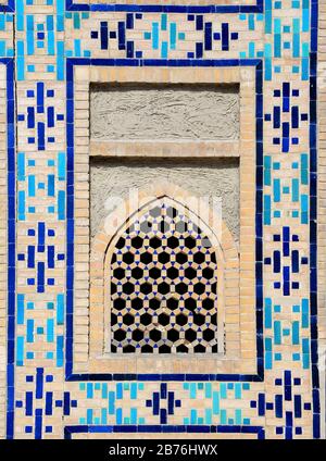 Majolika und symmetrische Keramikfliesen ornament um das Fenster von Ulugh Beg Madrasah, das sich auf dem Registroplatz in Samarkand, Usbekistan befindet. Stockfoto