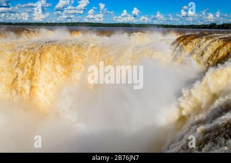 Blick auf einen Teil des Garganta del Diablo im Nationalpark Iguazú mit wolkigem Himmel und viel Laub auf der Rückseite Stockfoto